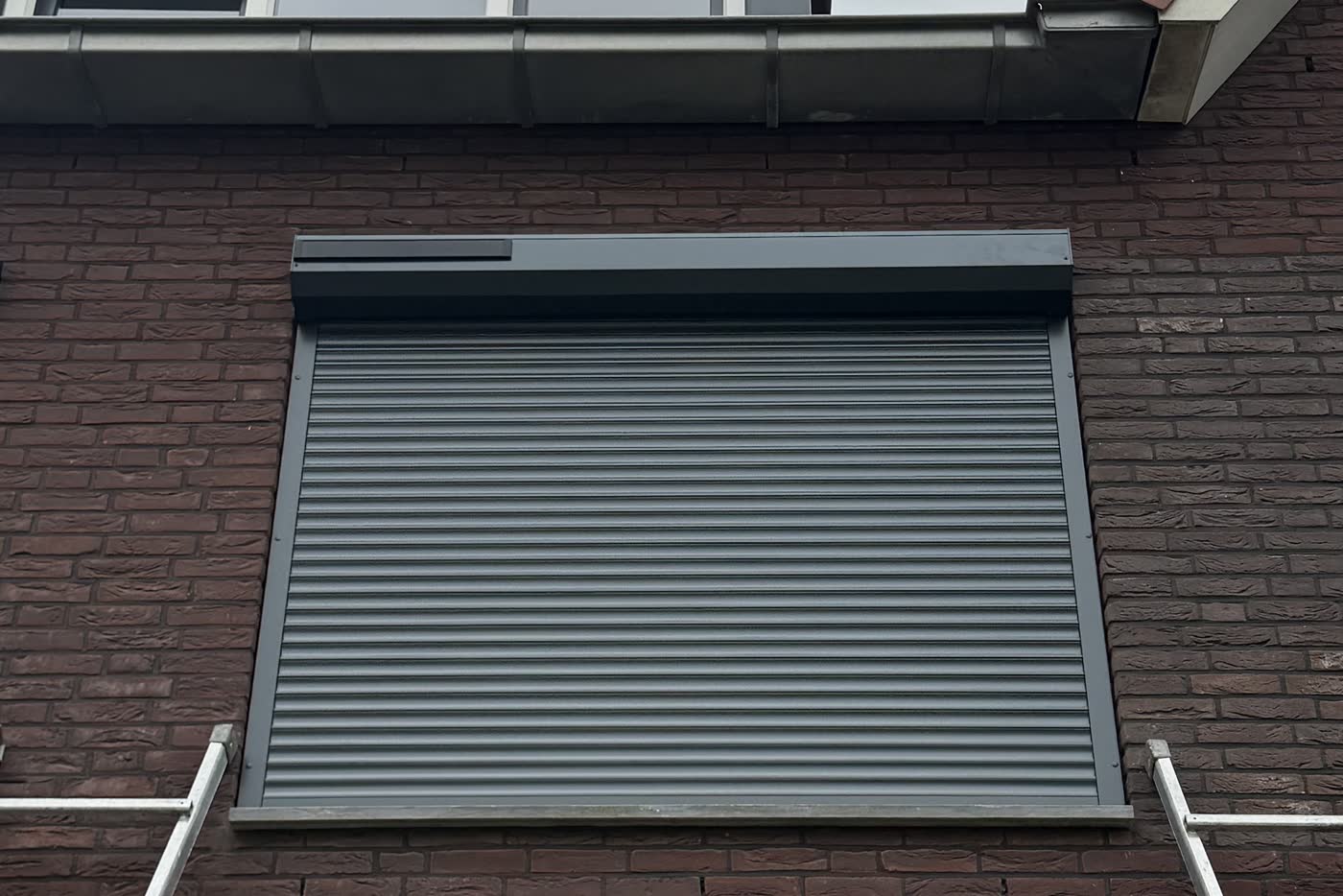 Breed antraciet solar rolluik, gesloten, op een eerste verdieping