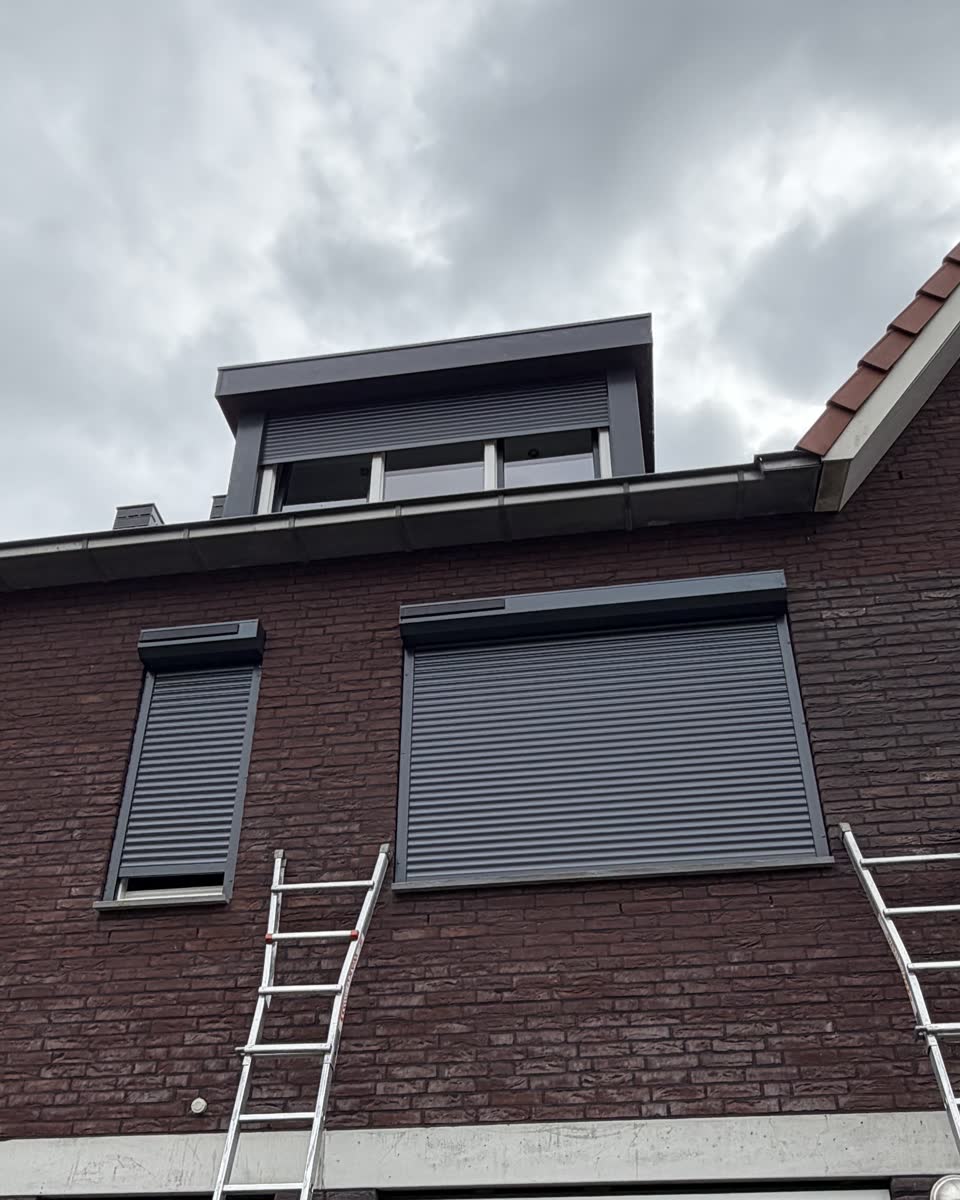 Voorgevel met twee gesloten antraciet rolluiken en twee ladders