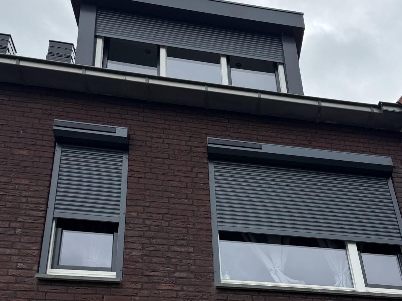 Dezelfde voorgevel met twee nieuwe antraciet solar rolluiken